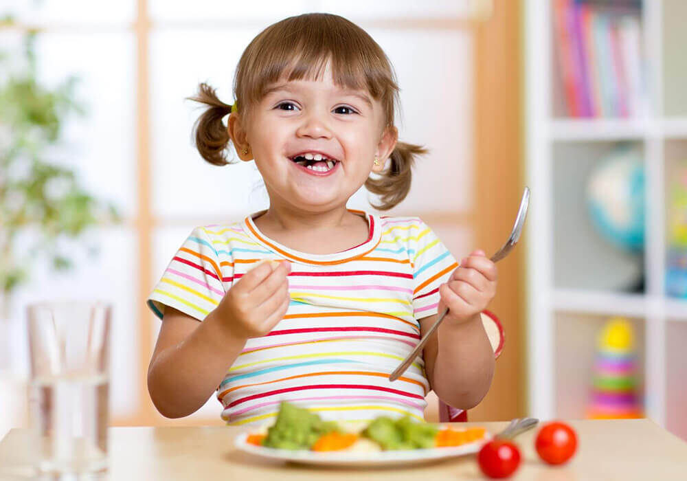 Kid enjoying her veggies